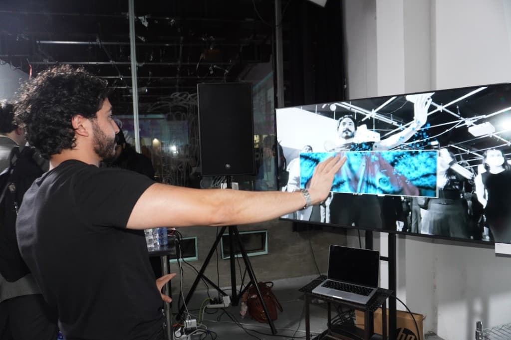 Someone reaching toward a large interactive screen.
